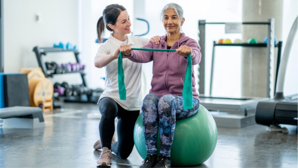 Frau, die am Gymnatikball Übungen macht