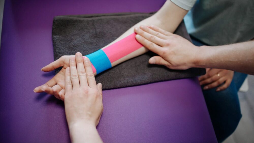 Frau die sich Tapen lässt in der Physiotherapie