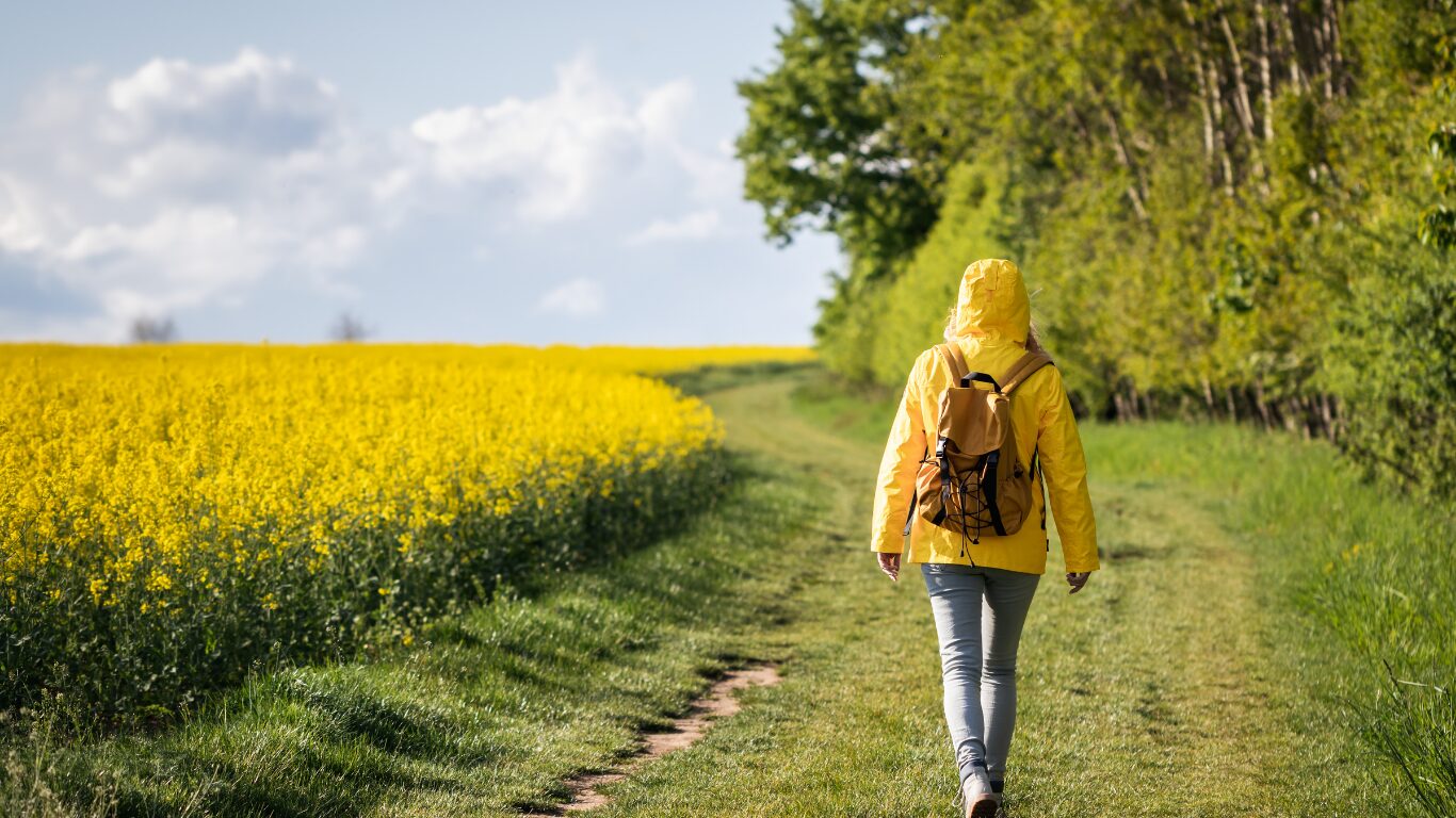 Frau spaziert über Frühlingswiese